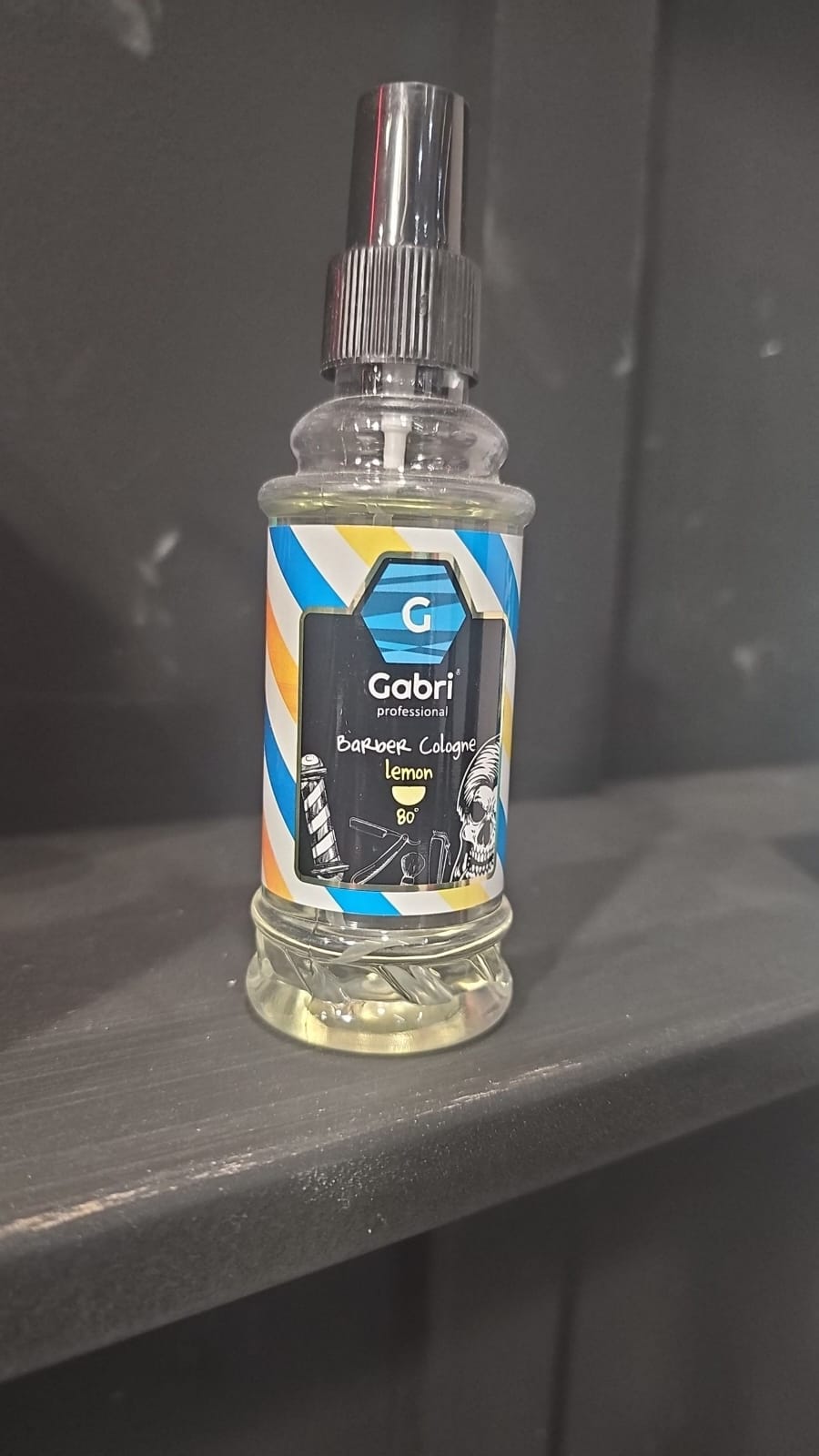 Clear spray bottle with a label on a dark surface